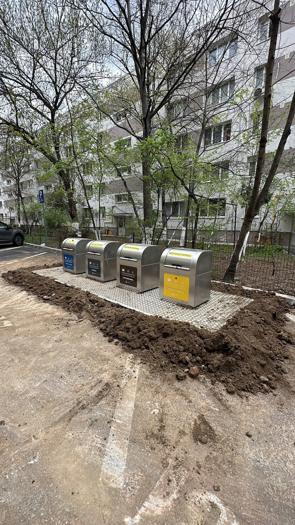 Patru containere semiîngropate din inox pentru colectare selectivă, montate pe o platformă nouă lângă un bloc